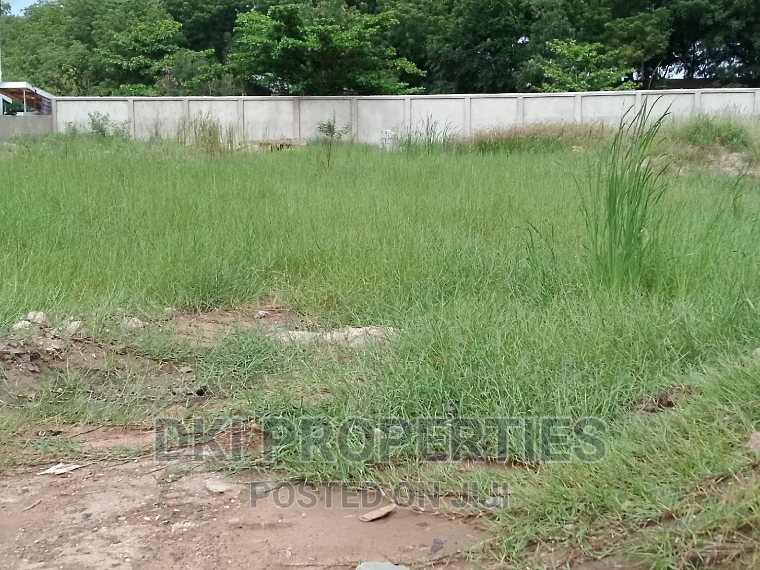 Photo of a fenced, titled plot of land in the Abelenkpe area of Accra, ready for mixed-use development with utility connections.