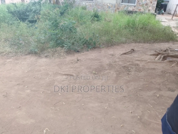 Photo of a cleared plot of mixed-use land in a developed part of Amrahia, Adenta, with visible electric and water connections nearby.