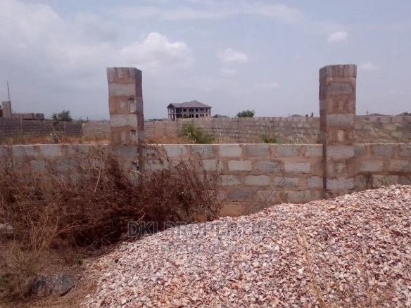 Image of a fenced, titled plot of land in Amrahia, a suburb of Adenta, ready for mixed-use development.
