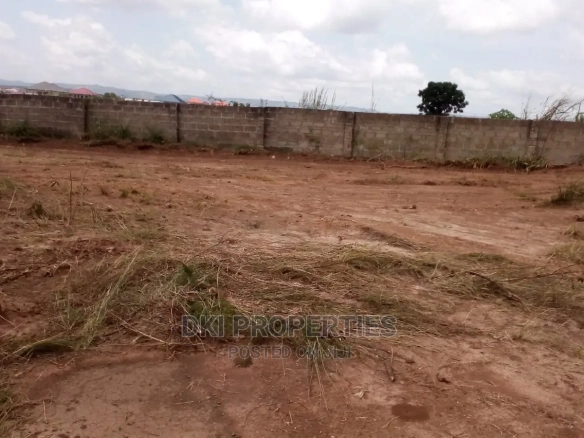 View of a developing estate community in Amrahia, Adenta with laid-out plots, electric poles, and water connections, ready for mixed-use development.