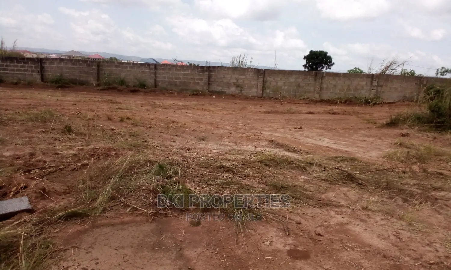 View of a developing estate community in Amrahia, Adenta with laid-out plots, electric poles, and water connections, ready for mixed-use development.