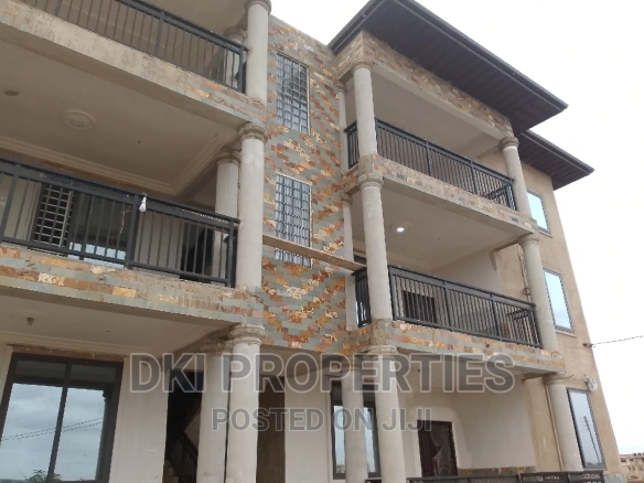 Exterior view of a newly-built, neat 2-bedroom apartment complex in Amrahia, Adenta, highlighting the modern façade and spacious compound/parking area.