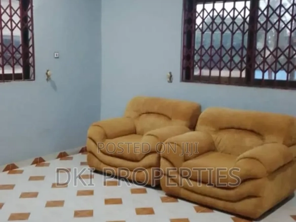 Interior view of a neat and spacious unfurnished Chamber and Hall (1-bedroom self-contained) apartment in Oyarifa, showing the tiled floor, Pop Ceiling, and fitted kitchen area.