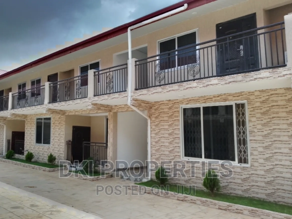 Exterior view of a newly-built, neat 2-bedroom apartment complex in Amrahia, showing the modern façade and spacious compound/parking area.
