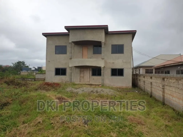 Exterior view of a large, 90% completed 4-bedroom detached house in Danfa, Adenta Municipality, showing the spacious structure and the large compound area indicative of a double plot.