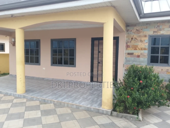 Exterior view of a newly-built, elegant 3-bedroom detached house in an Oyibi gated community, showcasing the tiled compound, modern architecture, and fenced perimeter.