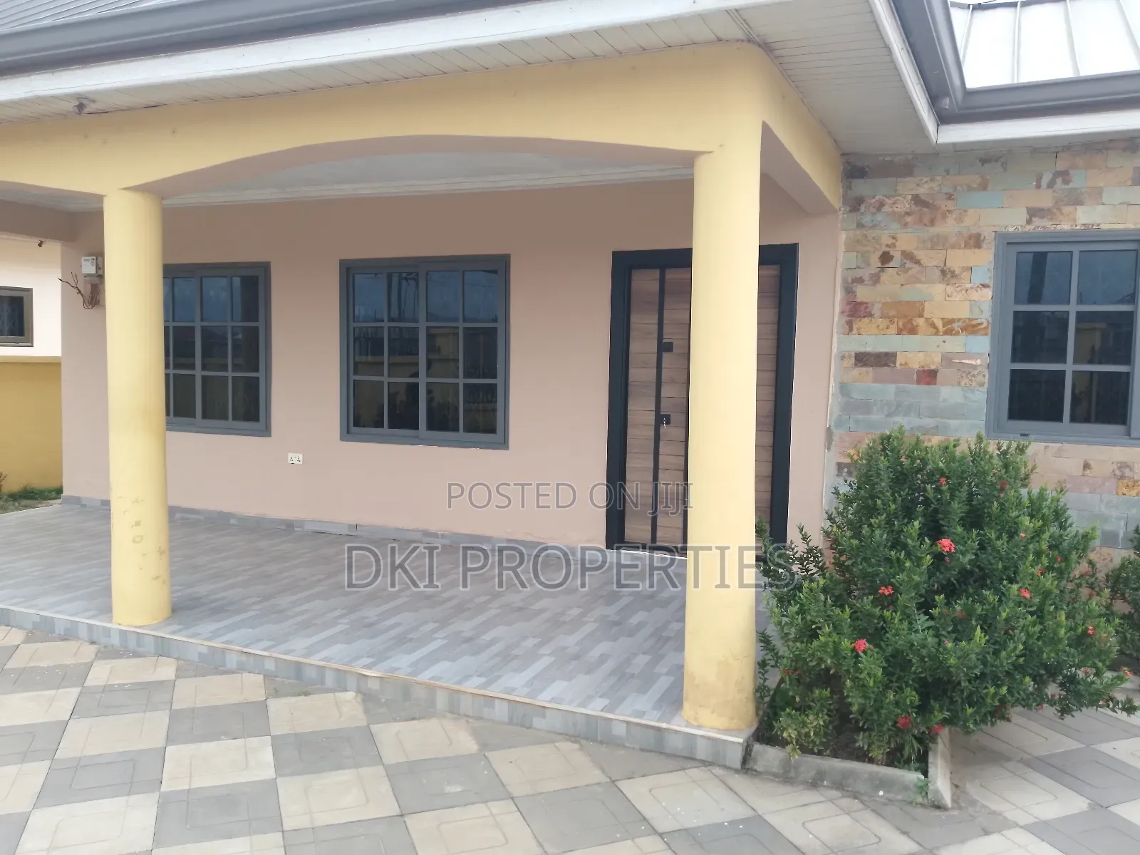 Exterior view of a newly-built, elegant 3-bedroom detached house in an Oyibi gated community, showcasing the tiled compound, modern architecture, and fenced perimeter.