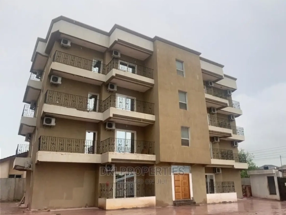 Exterior view of a newly-built, secure, and modern block of 16 residential apartments in West Legon, featuring multiple balconies and ample parking space.