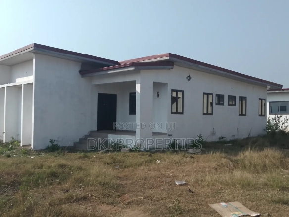 Exterior view of a newly-built, unfurnished 3-bedroom detached house in Amrahia, Adenta, showing the fenced and gated perimeter and parking space.