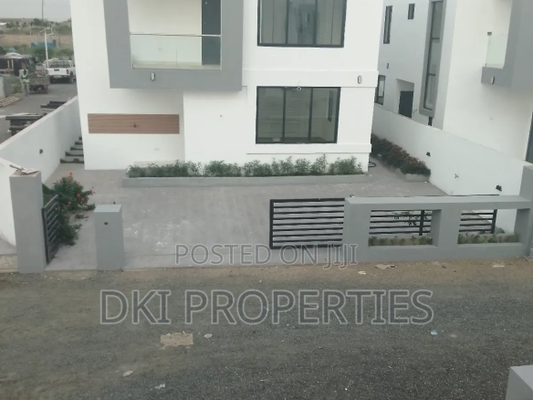 Exterior view of a newly-built, semi-furnished 3-bedroom detached house in Amrahia, Adenta, highlighting the modern architecture and spacious compound with parking for $\text{4}$ cars.