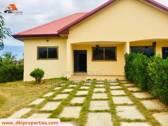Exterior view of a newly-built, semi-detached 1-bedroom duplex in Gomoa Fetteh, showing the modern architecture and parking space, suggesting a serene coastal community.