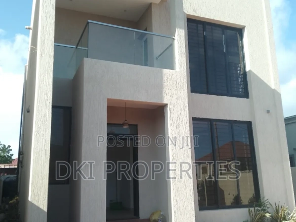Exterior view of an exquisite, newly-built 4-bedroom detached house in Adenta New Legon, highlighting the state-of-the-art finishings and spacious compound for multi-car parking.